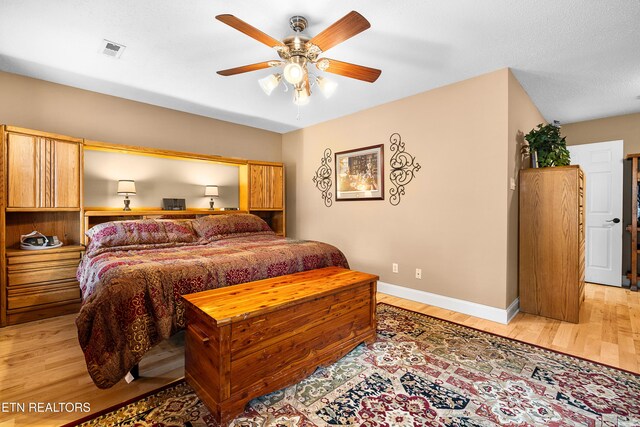 bedroom featuring light wood-style floors, baseboards, and a ceiling fan