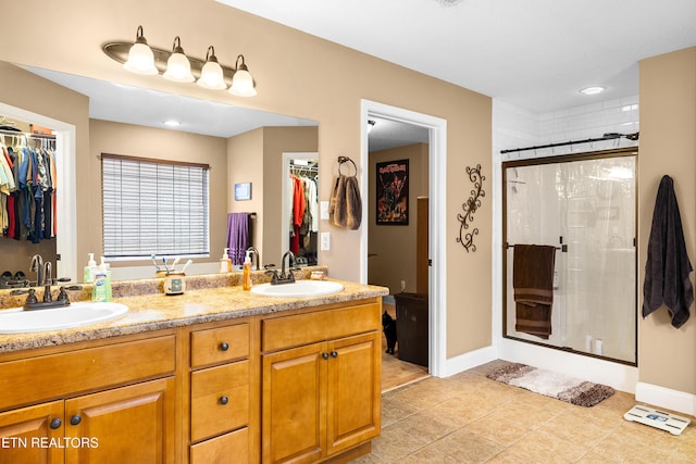full bath featuring a stall shower, a spacious closet, and double vanity