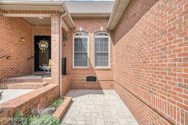 13 Holly Ct, Crossville, TN 38558 - doorway to property featuring brick siding, a shingled roof, and a patio area