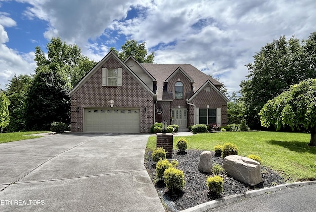 traditional-style home featuring brick siding, driveway, a front lawn, and a garage