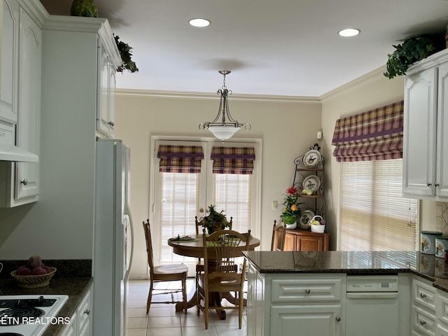 kitchen featuring freestanding refrigerator, a peninsula, light tile patterned flooring, white cabinetry, and crown molding
