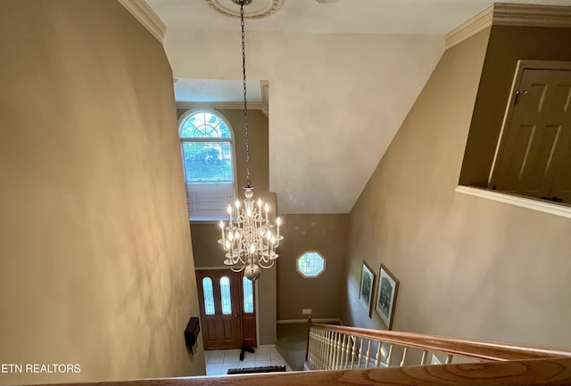 tiled foyer featuring a high ceiling and a chandelier