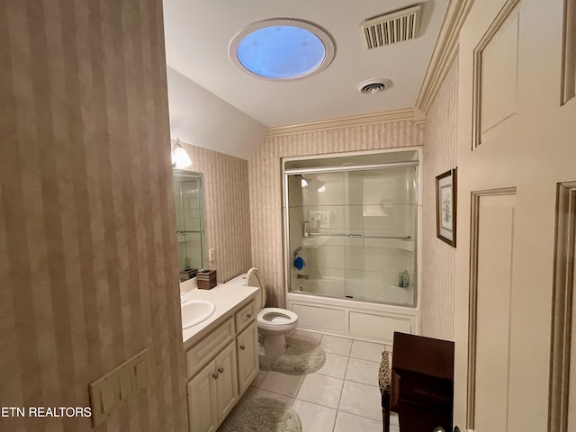 bathroom featuring toilet, vanity, tile patterned flooring, enclosed tub / shower combo, and wallpapered walls