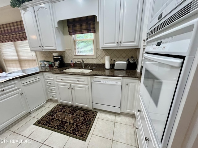 kitchen featuring white appliances, a sink, white cabinets, and tasteful backsplash
