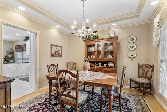 704 Blue Dun Ct, Pigeon Forge, TN 37863 - dining space featuring a chandelier, ornamental molding, light wood-type flooring, a raised ceiling, and baseboards