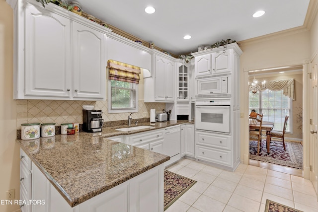 704 Blue Dun Ct, Pigeon Forge, TN 37863 - kitchen featuring white appliances, a sink, white cabinetry, a peninsula, and decorative backsplash