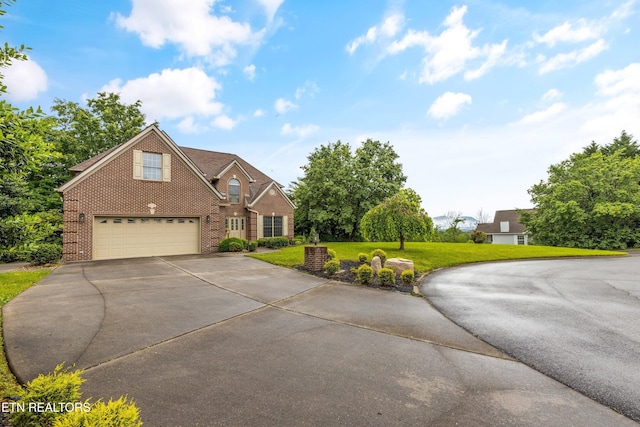 704 Blue Dun Ct, Pigeon Forge, TN 37863 - view of front facade featuring driveway, brick siding, a garage, and a front lawn
