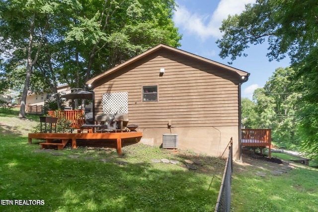back of property featuring a lawn, central AC unit, and a wooden deck
