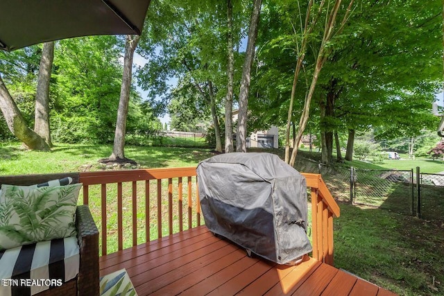 wooden deck with a yard, area for grilling, and a fenced backyard