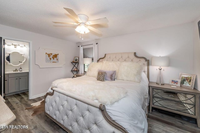 bedroom with a ceiling fan, a textured ceiling, baseboards, ensuite bathroom, and wood finished floors