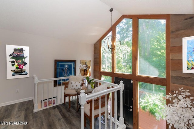 interior space featuring baseboards, wood finished floors, and vaulted ceiling