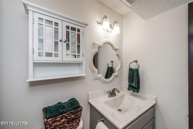 bathroom with vanity, a textured ceiling, and visible vents