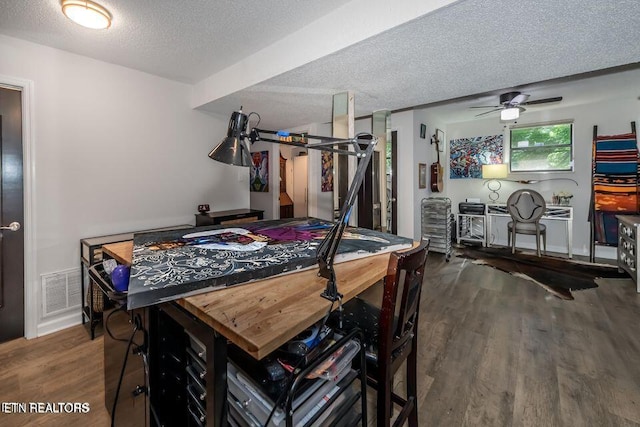 dining area with a textured ceiling, visible vents, wood finished floors, and a ceiling fan