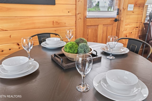 dining room featuring wood walls