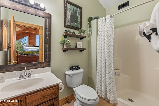 bathroom with a shower stall, toilet, vanity, and baseboards