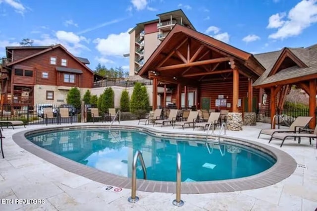 community pool featuring fence and a patio area