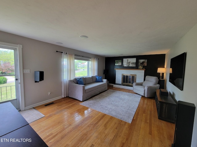 8008 Sharp Rd, Powell, TN 37849 - living area featuring a brick fireplace, baseboards, visible vents, and light wood-style floors
