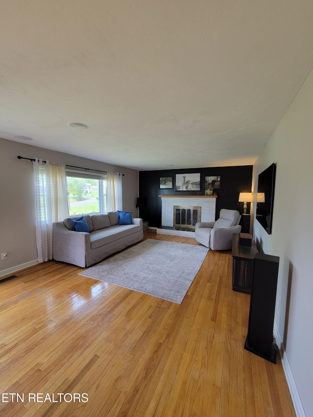 8008 Sharp Rd, Powell, TN 37849 - living room with light wood finished floors, a brick fireplace, baseboards, and visible vents