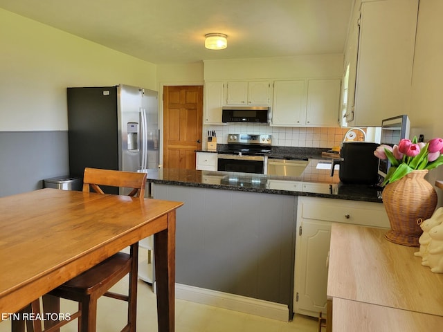 8008 Sharp Rd, Powell, TN 37849 - kitchen featuring white cabinetry, a peninsula, dark stone countertops, backsplash, and stainless steel appliances
