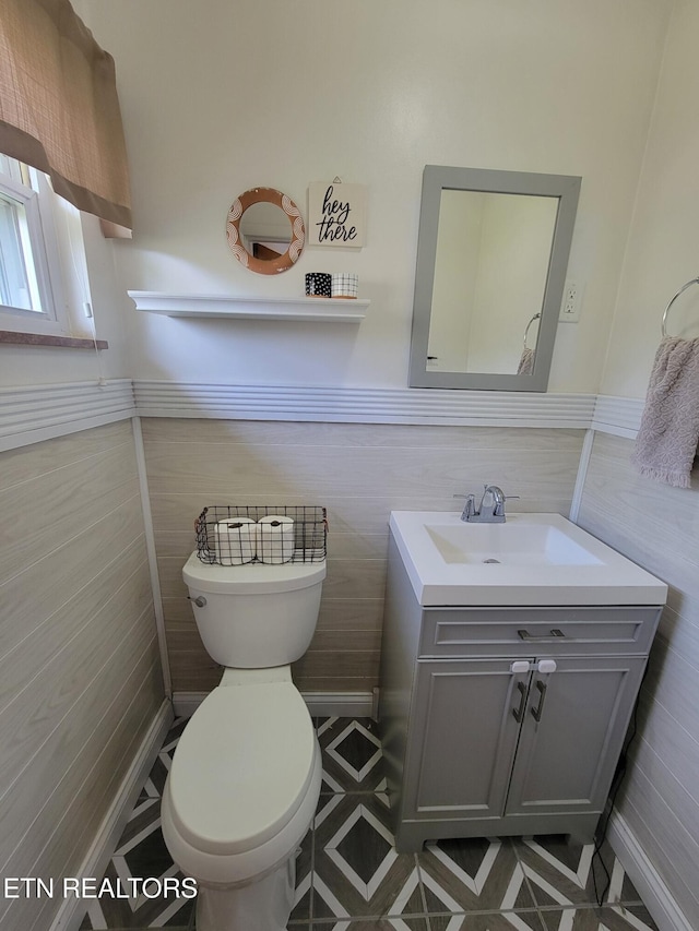 8008 Sharp Rd, Powell, TN 37849 - bathroom with tile walls, toilet, vanity, and a wainscoted wall