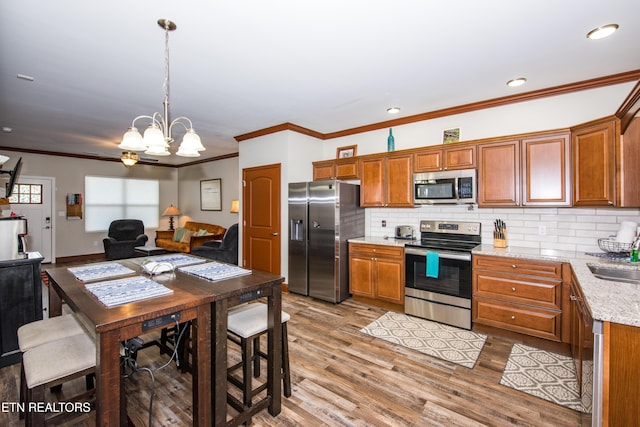 229 Bishops Cap Cir Unit 106, Townsend, TN 37882 - kitchen featuring appliances with stainless steel finishes, a sink, brown cabinetry, crown molding, and recessed lighting