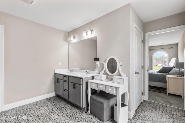 bathroom with ensuite bath, baseboards, double vanity, and tile patterned floors