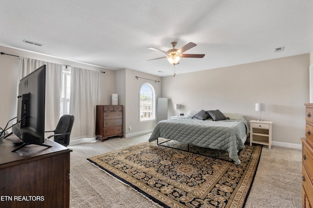 bedroom featuring light colored carpet, baseboards, and ceiling fan