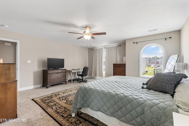 carpeted bedroom with ceiling fan, baseboards, and a desk