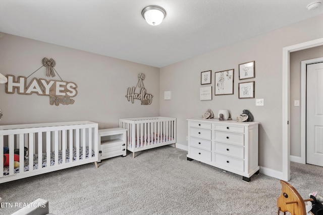 bedroom with carpet flooring, a crib, and baseboards