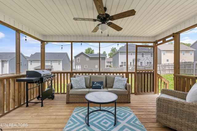 sunroom / solarium with a residential view, outdoor lounge area, and a ceiling fan