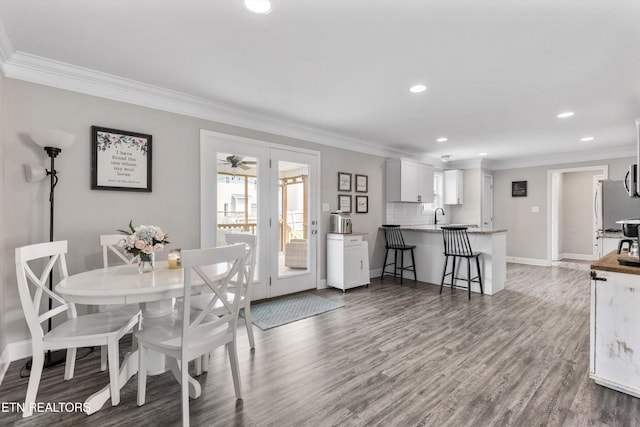 dining room featuring crown molding, wood finished floors, recessed lighting, and baseboards