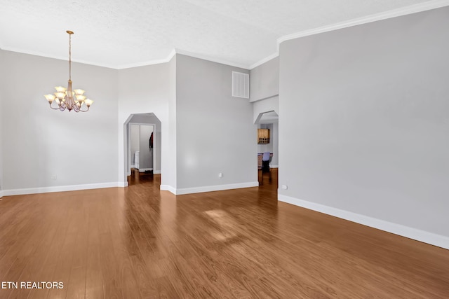 791 Constitution Dr, Jefferson City, TN 37760 - unfurnished living room featuring a chandelier, ornamental molding, baseboards, wood finished floors, and arched walkways