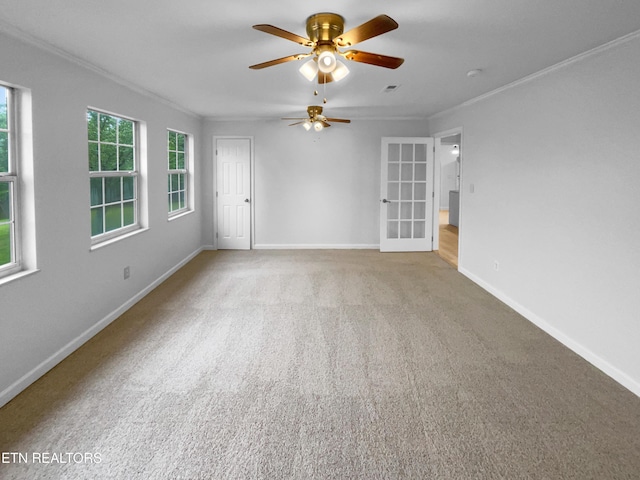 spare room with ornamental molding, ceiling fan, baseboards, french doors, and carpet flooring