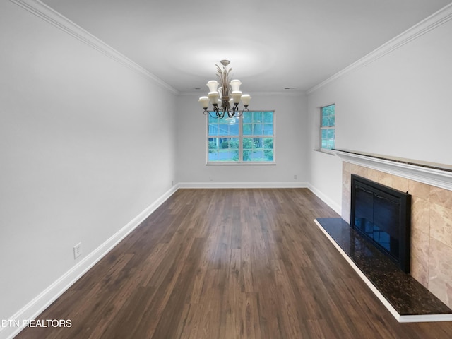 unfurnished living room featuring dark wood-style floors, a chandelier, baseboards, a fireplace, and crown molding