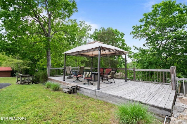 wooden terrace featuring a lawn and a gazebo