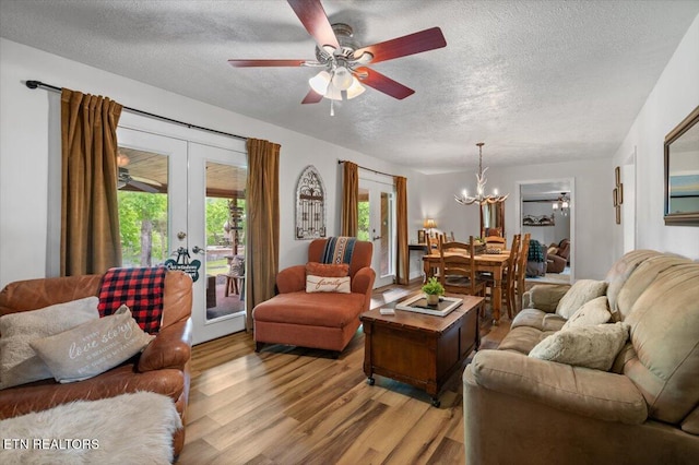 living area with a textured ceiling, french doors, and wood finished floors