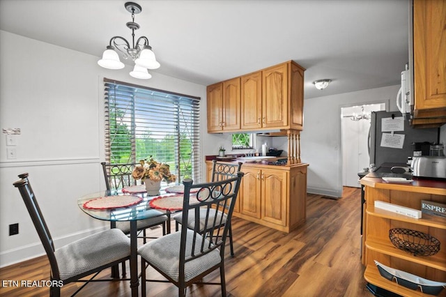 kitchen with baseboards, dark wood-style flooring, a notable chandelier, and hanging light fixtures