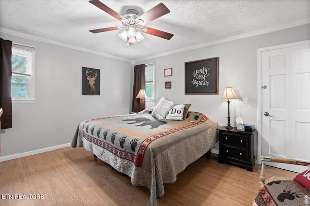 bedroom with ornamental molding, multiple windows, and light wood-style floors