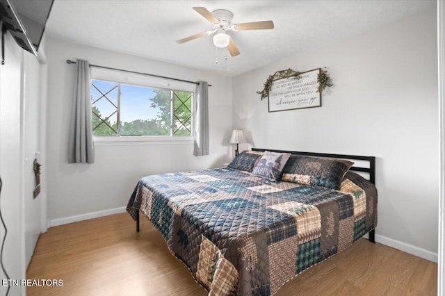 bedroom with wood finished floors, baseboards, and ceiling fan