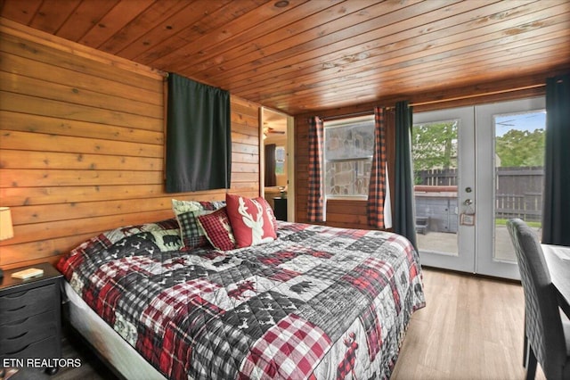 bedroom with wood walls, french doors, wood finished floors, wooden ceiling, and access to outside