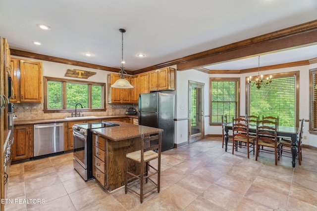 6605 Lammie Branch Ln, Knoxville, TN 37938 - kitchen with stainless steel appliances, crown molding, a sink, a chandelier, and tasteful backsplash