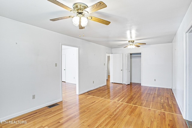 unfurnished bedroom with baseboards, light wood-style flooring, ceiling fan, and a closet