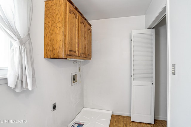 laundry room featuring cabinet space, hookup for a washing machine, electric dryer hookup, wood finished floors, and baseboards