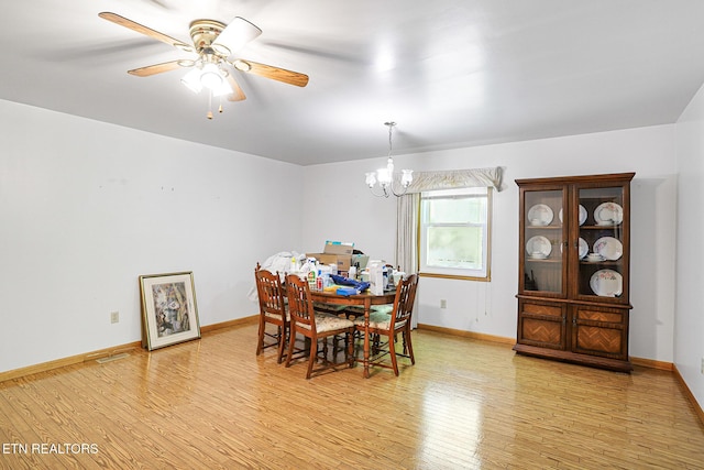 dining room featuring a chandelier, light wood-style flooring, baseboards, and ceiling fan