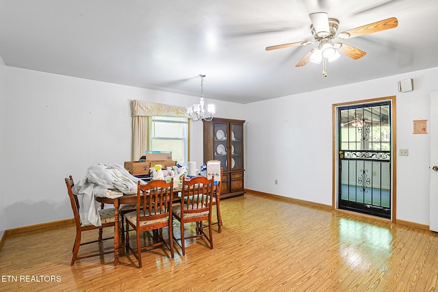 dining area with a chandelier, light wood-style flooring, baseboards, and ceiling fan