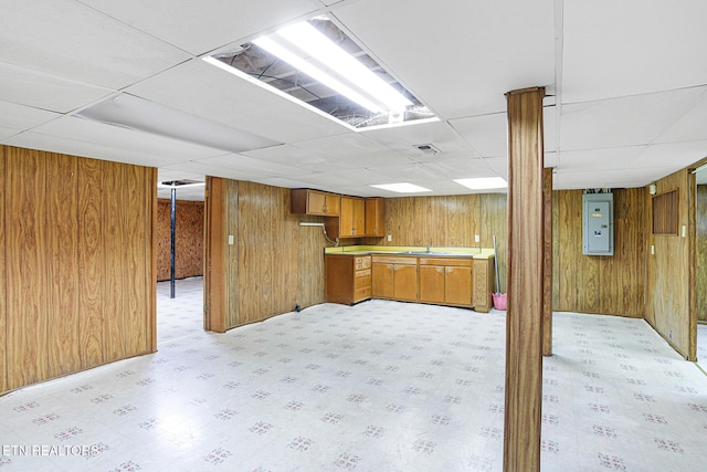 finished basement with a paneled ceiling and wooden walls