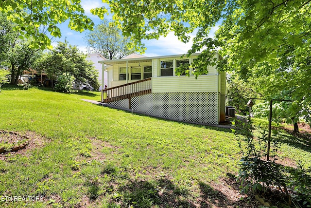 back of house with a yard and central air condition unit