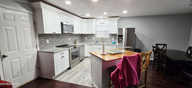 4808 Beverly Field Way, Knoxville, TN 37918 - kitchen featuring stainless steel appliances, decorative backsplash, white cabinetry, recessed lighting, and a breakfast bar