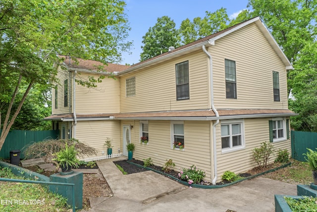 rear view of property featuring fence and a patio