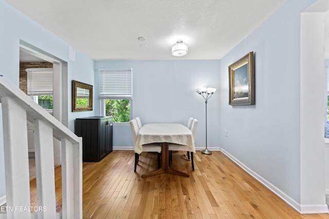dining room with baseboards and light wood finished floors
